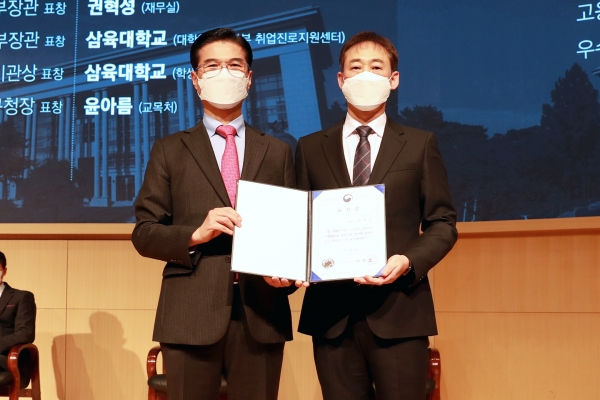 삼육대 재무실 권혁성(오른쪽) 과장과 김일목 총장이 표창장을 들고 기념사진을 찍고 있다.