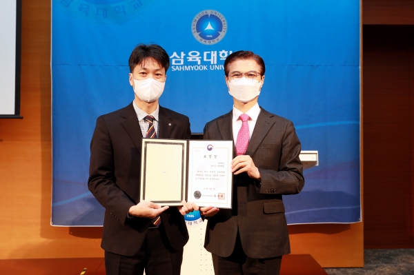 (왼쪽부터) 이재동 총장부속실 팀장과 김일목 총장이 표창장을 들고 기념사진을 찍고 있다.