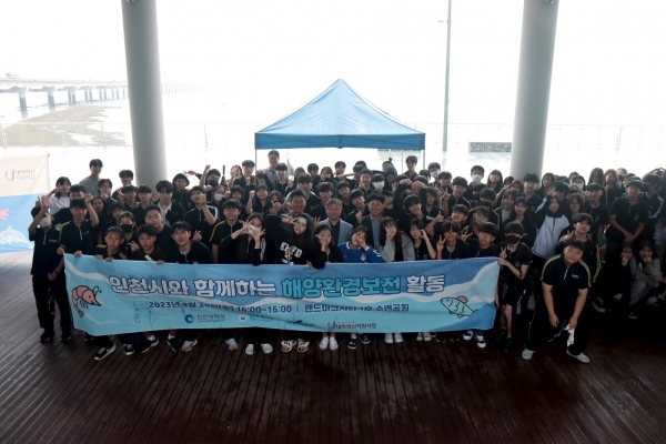 인하대학교 경기·인천 씨그랜트센터와 인천시가 함께 진행한 해양환경보전 캠페인에 참여한 학생, 인천 시민이 기념사진을 촬영하고 있다.